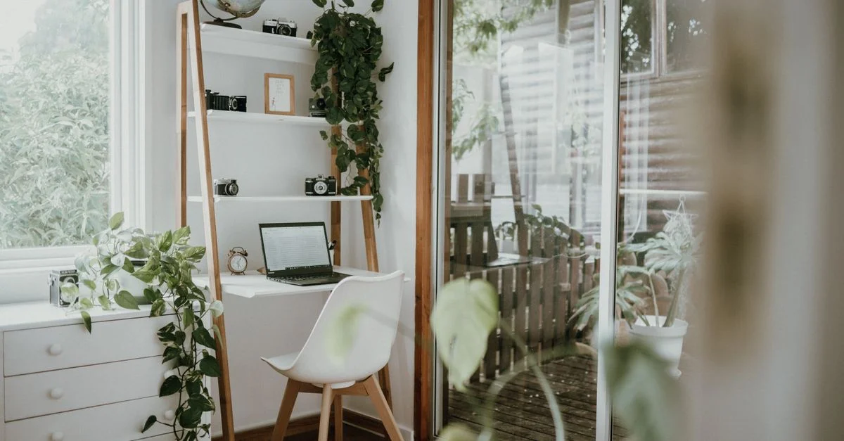 Bureau à domicile minimaliste au design scandinave, avec verdure et lumière naturelle.