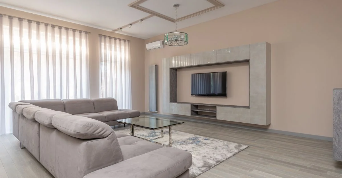 Salon minimaliste élégant avec décor beige, mobilier moderne et lumière naturelle.